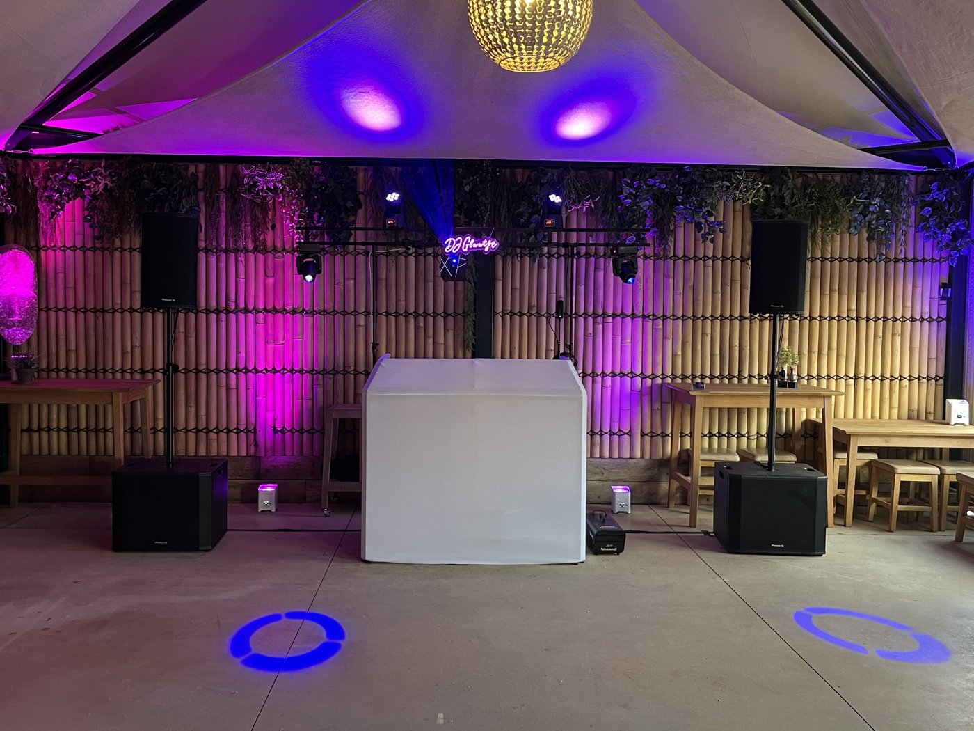 Exclusive Show setup met witte DJ booth, moving heads, paarse uplights en gobo-verlichting